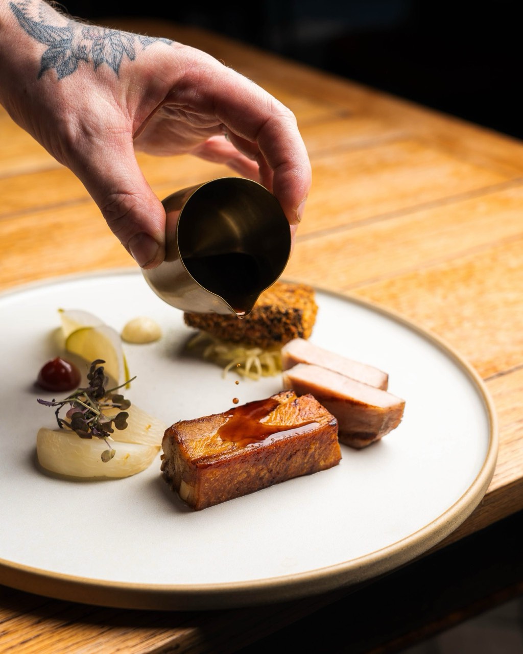 A plated course alongside a glass of wine at The Peacock Inn