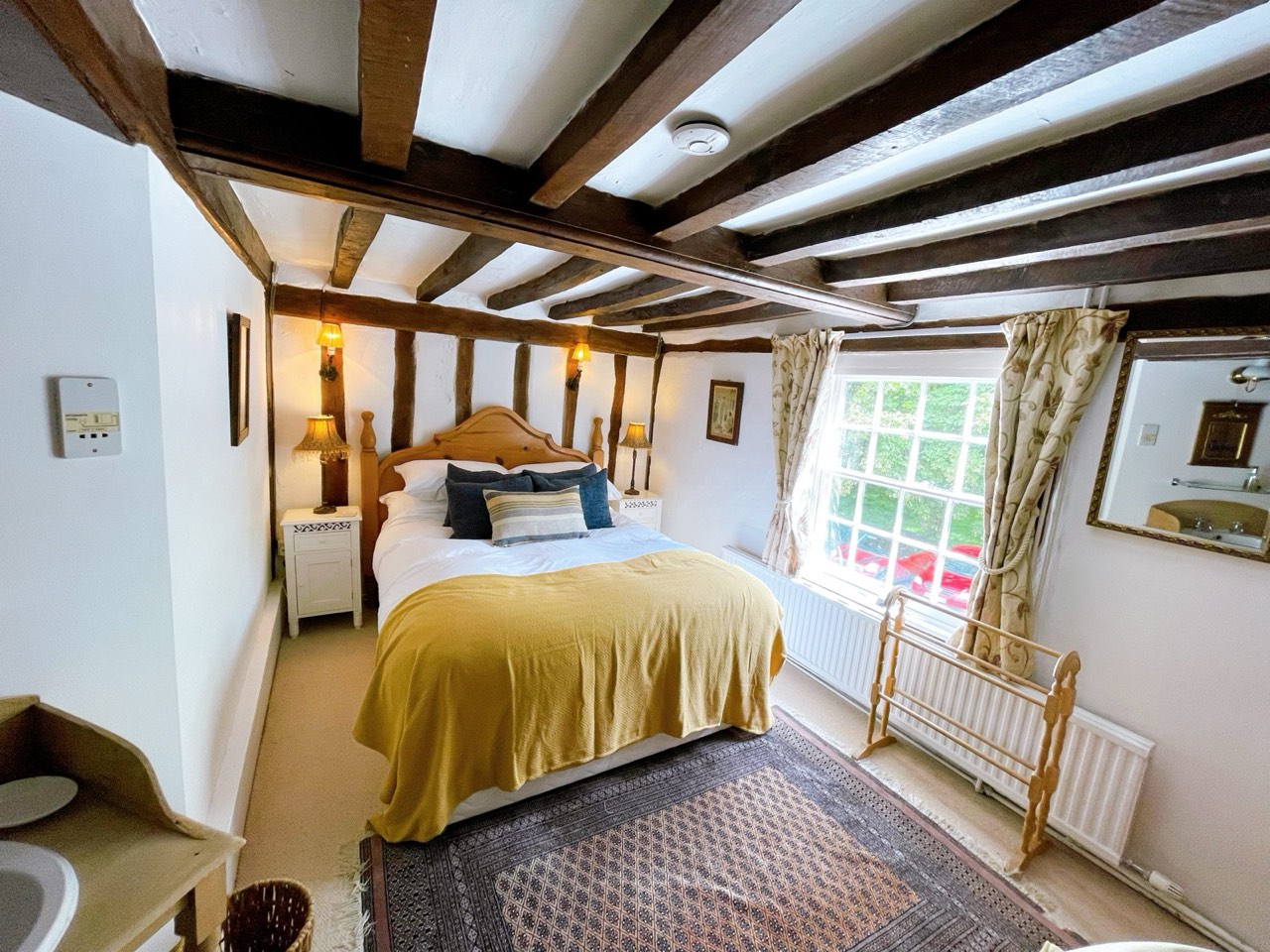 The Waveney inn room at The Peacock Inn, a large room with original beams, a fireplace and a king size bed at the front of the 14th-century inn